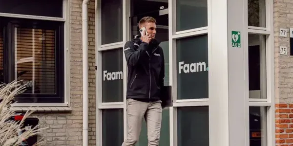 A Faam employee on the phone outside the office entrance