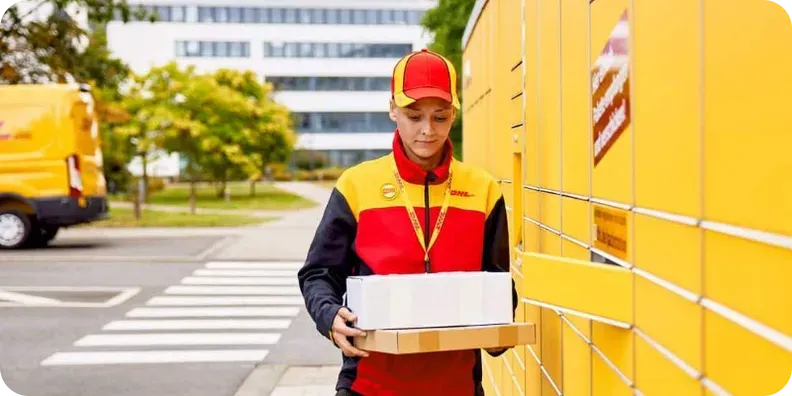 DHL courier in company uniform delivering two parcels to a yellow parcel locker