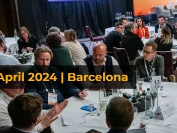 Attendees talking at round tables during the RecBuzz conference in Barcelona